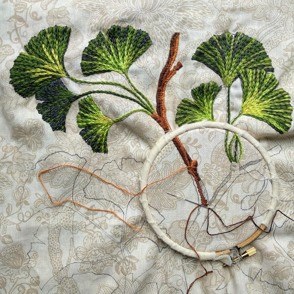 proceso de bordado a mano de un motivo floral de ginkgo biloba