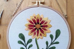 Bastidor con bordado botánico de una flor hecho a mano y finalizado