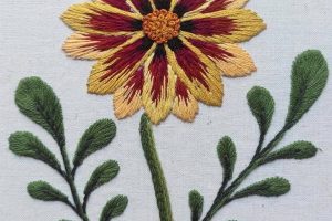 Detalle desde arriba del bordado botánico de una flor hecho a mano