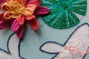 foto de detalle de bordado en relieve de flores y peces y del proceso de bordado