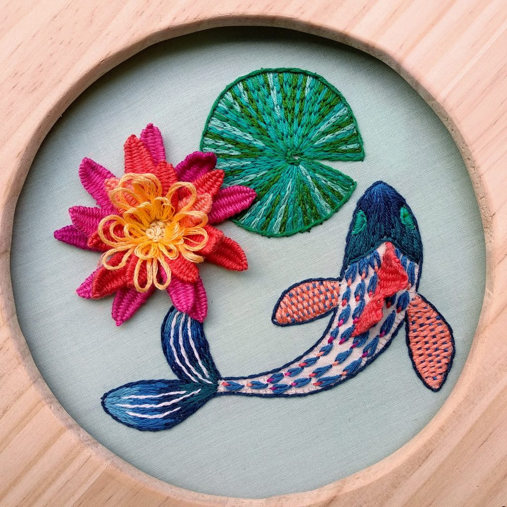 Bordado en relieve de flores y peces finalizado y enmarcado