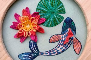 Bordado en relieve de flores y peces finalizado y enmarcado