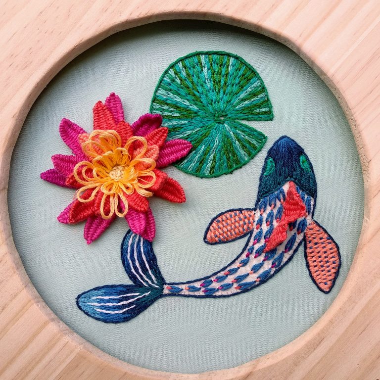 Bordado en relieve de flores y peces finalizado y enmarcado