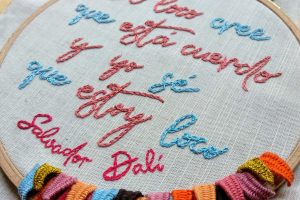 foto de detalle bordado manual stumpwork y letras frase salvador dali